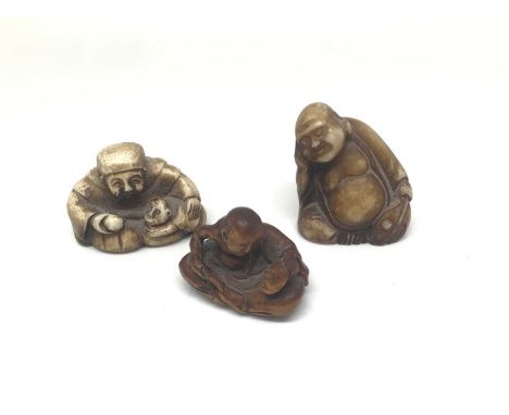 Carved wood netsuke of a seated man making a mask, character mark to base, and two other small resin figures (3)