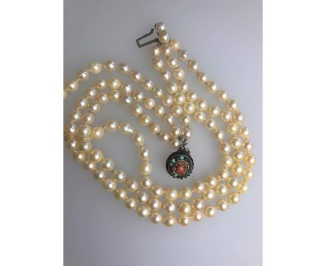 A triple row uniform cultured pearl choker knotted throughout onto circular white metal garnet, turquoise and coral set snap,