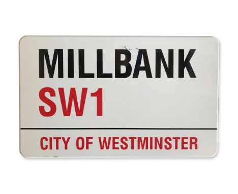An enamelled iron street sign for Millbank SW1, City of Westminster with iconic black and red sans serif lettering first crea