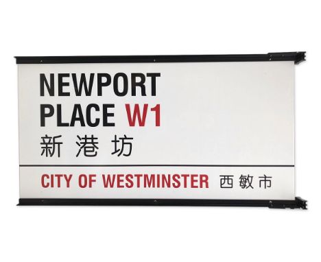 A double sided enamelled iron street sign on brackets for Newport Place W1 Chinatown, City of Westminster with iconic black a