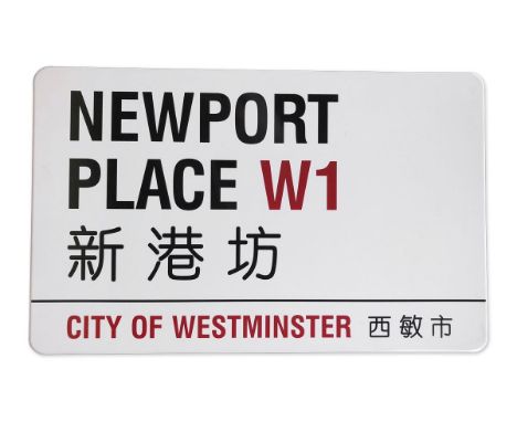 An enamelled iron street sign for Newport Place Chinatown W1, City of Westminster with iconic black and red sans serif letter