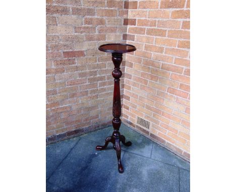 A CARVED MAHOGANY TORCHERE  on tripod base 124cm high, the circular top 30cm diameter