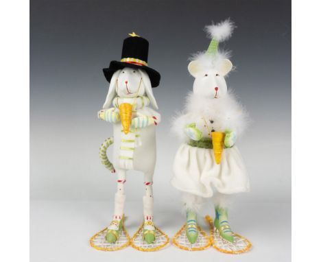Designed by Patience Brewster. 2 figures of white dogs, a gentleman and a lady, wearing snow shoes and snowman carrot nose. T