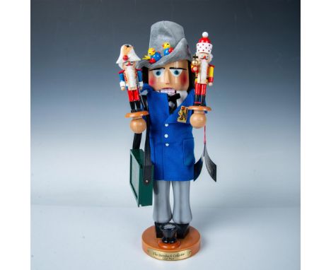 A nutcracker gentleman, clad in a sharp blue jacket and gray pants, with a Steinbach Collectors Club Kit briefcase, showcases
