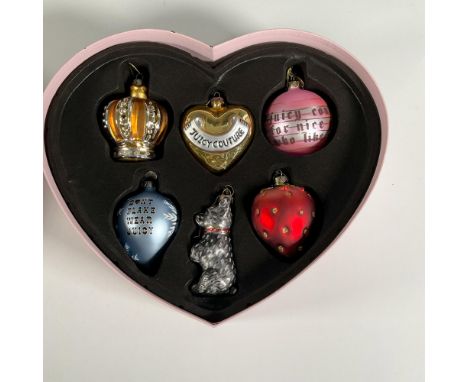 This collection of embossed glass ornaments all feature iconic images of Juicy Couture housed in a pink heart box. Largest pi