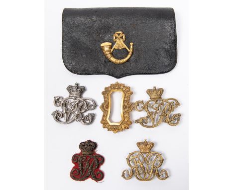 A Victorian bullion embroidered crowned "VR" forage cap badge; a gilt pouch badge with crowned reversed "VR" cypher; a brass 
