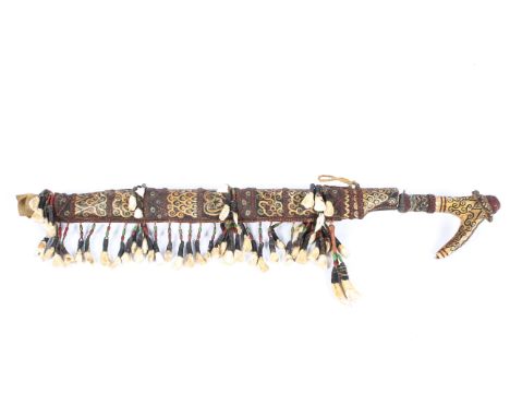 A 20th century Mandau Dayak 'Head Hunters' sword with scabbard, the sword with an engraved iron blade and ornately carved ant