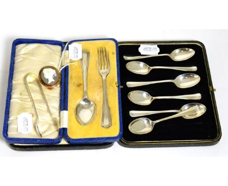 A set of six silver coffee spoons; a silver christening spoon and fork; a pair of silver sugar tongs and a shell cameo brooch