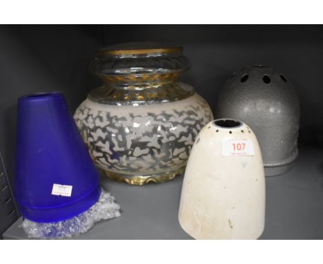 A collection of vintage lamp shades including two industrial metal shades and three of blue glass.