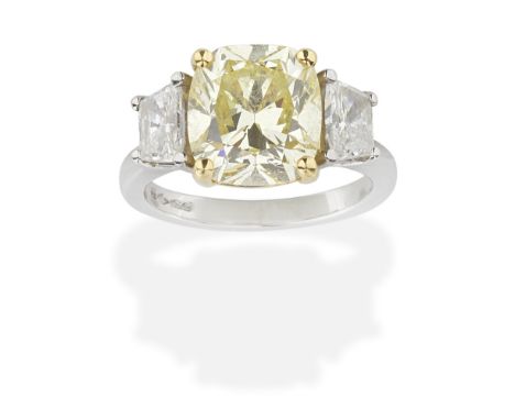 COLOURED DIAMOND AND DIAMOND RINGCushion-shaped diamond, weighing 4.24 carats, between trapezoid-cut diamonds, mounted in pla