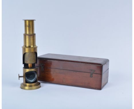 A brass field microscope with wooden case and three additional lenses, seller's label to inside of box
