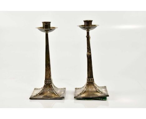 AFTER JAN EISENLOEFFEL FOR JAMES DIXON &amp; CO; a pair of Edward VII hallmarked silver Arts &amp; Crafts candlesticks, with 