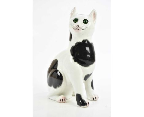 WEMYSS WARE; a black and white earthenware cat with green glass eyes, signed to the underside, height 33cm.Condition Report: 