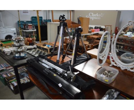 Three camera tripods and a projector screen