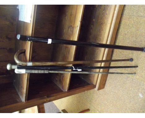 Three walking sticks to include one with antler handle, together with an ebonised shafted swagger stick