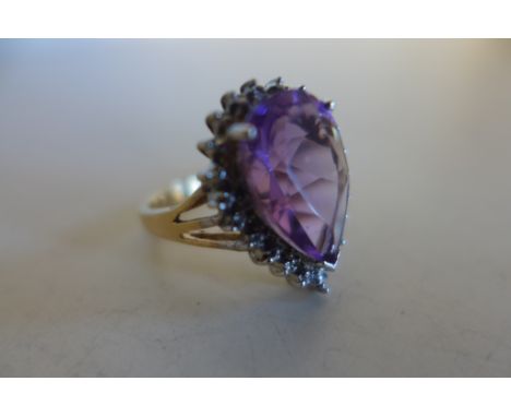 A 9ct gold amethyst and diamond ring, with a large teardrop shape amethyst, approx 15mm x 10mm, with 3 small diamonds in whit