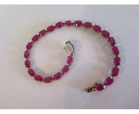 A pretty 9ct gold and ruby bracelet in as new condition, set with 24 oval rubies, each measuring approx 6x4mm - with a small 