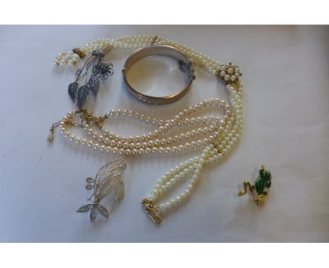 Two imitation pearl necklaces, a silver bangle, two filigree brooches and a frog brooch 