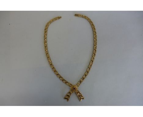 A modern substantial 9ct gold necklace with a fancy chevron link chain, cross over set with a sunburst design and a central s