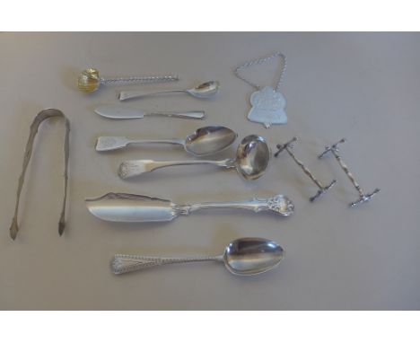 A collection of Georgian and later silver flatware including sauce ladle, butter knives, sugar nips, knife rests etc, and a Q