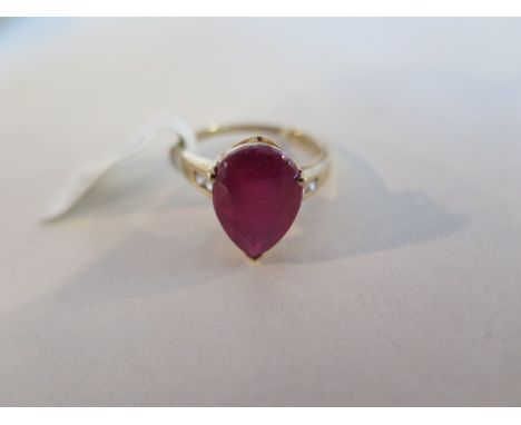 A 9ct gold ruby and zircon ring, set with a tear drop shape ruby of approx 6 carats, flanked by zircon stones set to the shou