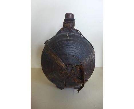 A carved moon shaped wooden flask, 26cm tall, with remains of leather strapping, general wear and crack to body 