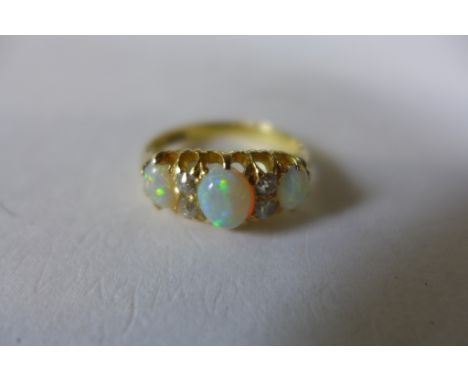 An 18ct gold opal and diamond ring, size J, approx 3.4 grams, opals bright and lively&nbsp;one opal has a small chip otherwis