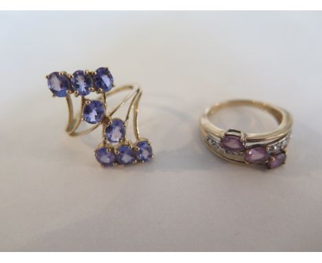 A large modern 9ct gold crossover ring, set with eight tanzanites and a 9ct amethyst and white stone ring, sizes N and O 1/2 