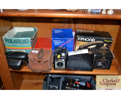 A collection of old camera equipment, an Inphone, compact video light etc