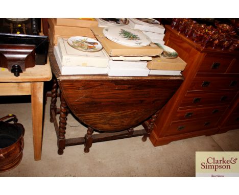 An oak gate leg dining table on barley twist supports