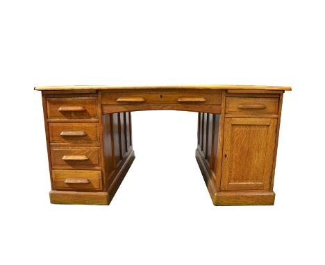 An Edwardian oak twin pedestal partners desk, possibly by Lebus, each aspect with a central drawer above the kneehole, flanke