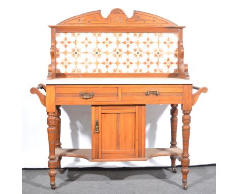 A Victorian walnut tile-backed washstand, the raised back with twelve inset tiles, above a white marble top, with two frieze 