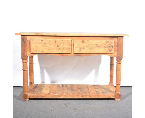 A pine dresser base, the rectangular top above two deep drawers, turned supports joined by an open shelf, width 122cm, depth 