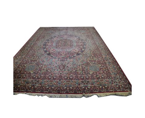 A large Persian pattern carpet, large central floral medallion against a dense floral field, enclosed by deep floral spandrel