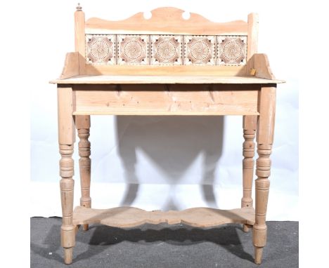 A stripped pine washstand with tile back, the shaped back inset with five Victorian decorative tiles, turned and ringed suppo