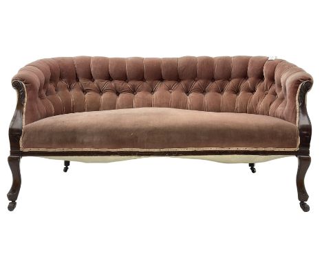 Late 19th century mahogany framed two-seat sofa, upholstered in buttoned pink fabric, on cabriole front supports, on castors 