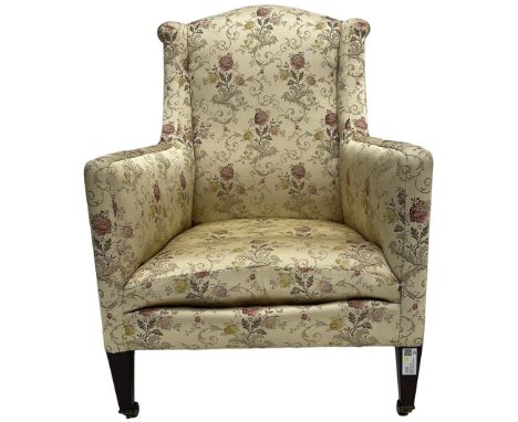 Edwardian hardwood-framed armchair, upholstered in floral pattern fabric, on square tapering front supports, brass and cerami