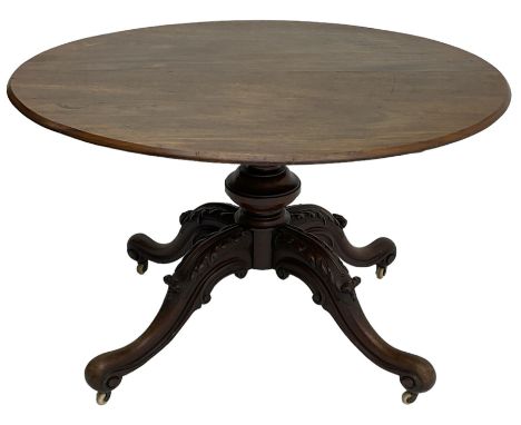 19th century mahogany loo table, oval tilt-top on turned pedestal, four out-splayed supports carved with acanthus leaves, scr