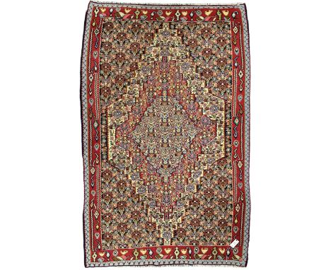 Senneh Kilim crimson ground rug, decorated with stylised plant motifs within overlapped lozenges, the border decorated with s