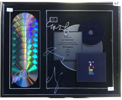 COLDPLAY SIGNED AWARD. A framed CD presentation with plaque to read 'Presented to Guy Berryman to recognise Worldwide sales i