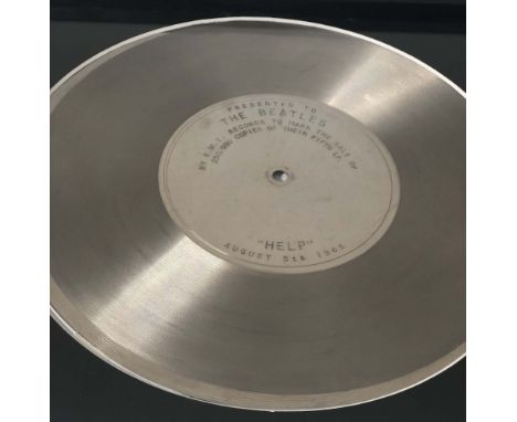 EMI PRESENTATION DISC FOR HELP. A mounted and framed presentation disc, presented to The Beatles by EMI to commemorate 250,00