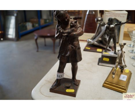 A vintage spelter figure of a girl with a cat