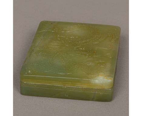 A Chinese carved jade boxOf shallow rectangular form, the removable lid carved with a dragon.  8 cm wide.  CONDITION REPORTS: