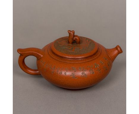 A Chinese Yixing pottery teapot Of squat oval globular form, decorated with calligraphy, the removable lid decorated with a m