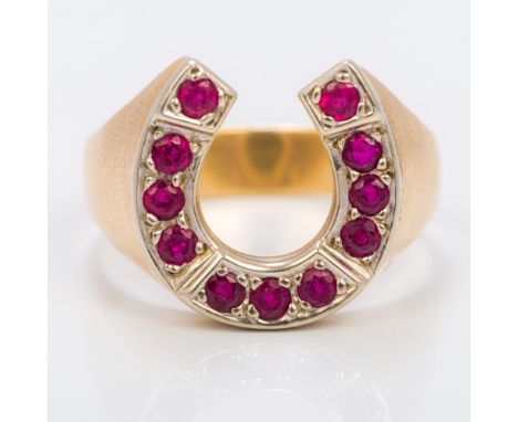 An unmarked gold gentleman's ruby set horseshoe ringSet with eleven rubies, each just under 1 1/6th carat.  1.7 cm high. Prov