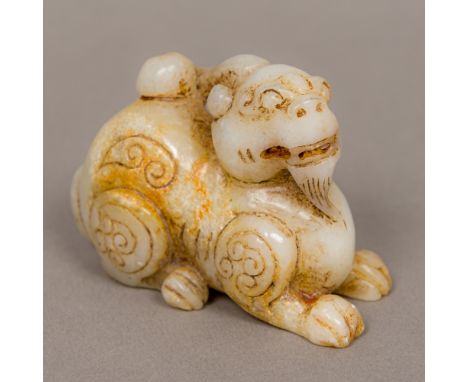 A jade carved mutton fat fo dog Modelled recumbent with incised decoration. 8 cm long. CONDITION REPORTS: Generally in good c