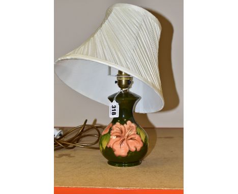 A MOORCROFT TABLE LAMP, decorated in the  Coral Hibiscus pattern on a green ground with a cream shade, height 23cm to top of 