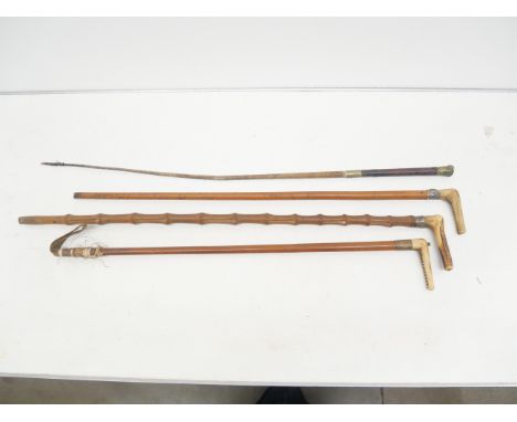 A collection of walking canes and a horse whip, one with fox detail