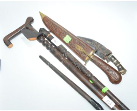 A group comprising tribal carved wooden axe, cane, kukuri, dagger