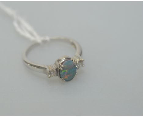 An opal and two stone diamond ring mounted on a platinum shank, size M/N